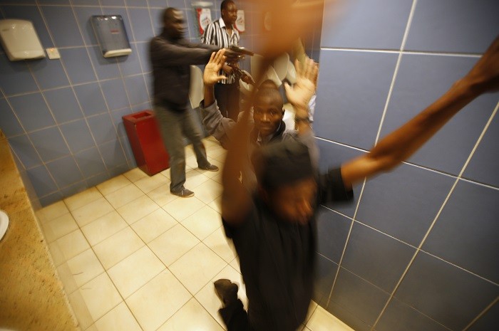 Armed police search customers taking cover inside a bathroom while combing through the Westgate shopping centre for gunmen