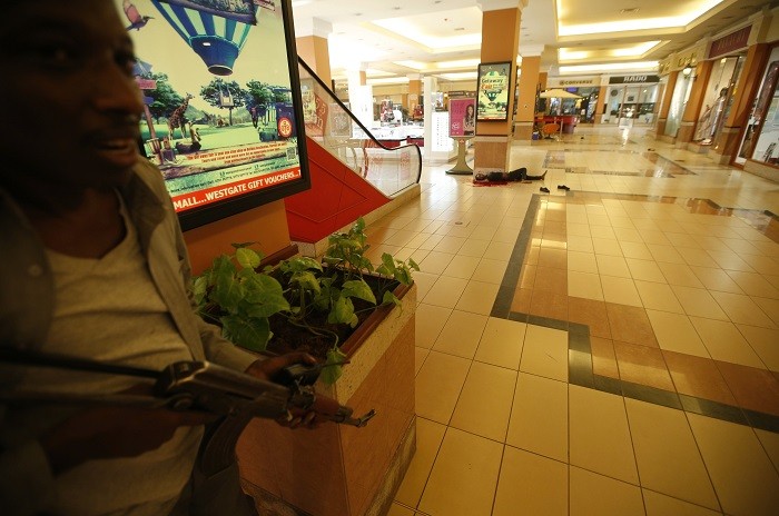 A body is seen as an armed police searches through the Westgate shopping centre for gunmen in Nairobi