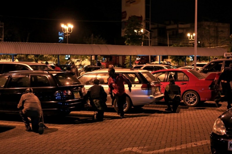People run for cover as the stand-off continues into the night at Westgate Shopping Centre in Nairobi September 21, 2013. 
