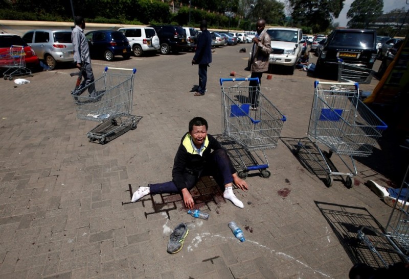 A wounded man sits screaming in shock at a parking lot of Westgate Shopping Centre in Nairobi September 21, 2013.