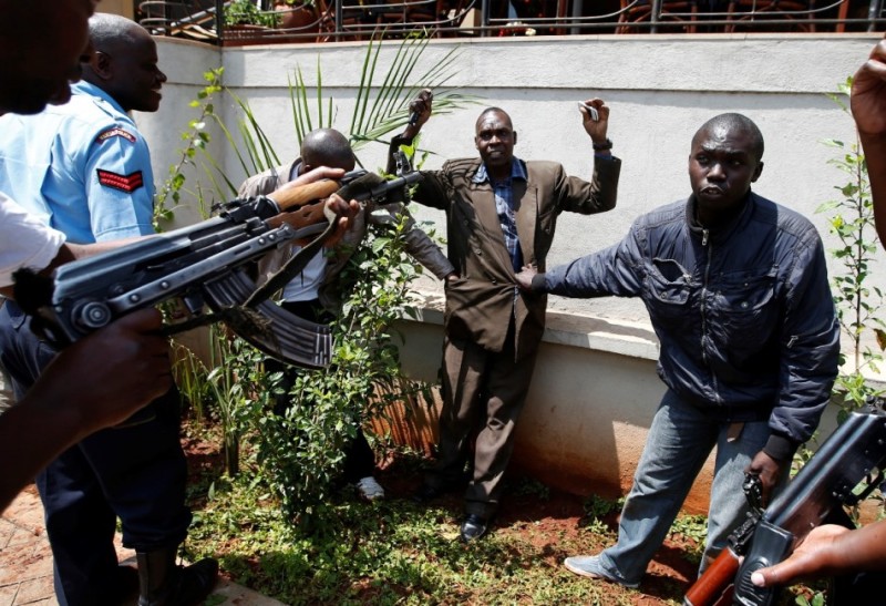 Policemen search a man for weapons as he walked out of Westgate Shopping Centre in Nairobi September 21, 2013. 